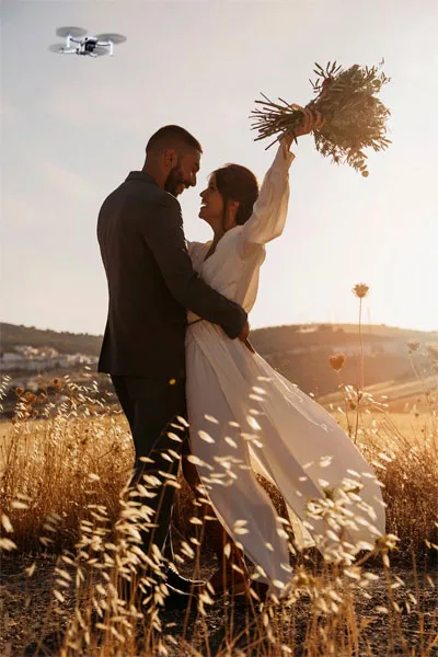Vidéo drone mariage des jeunes mariés dansant dans un champ au soleil couchant Wedding drone video of newlyweds dancing in a field at sunset
